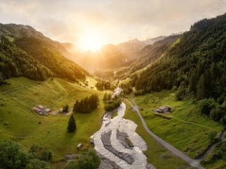 Ein Bild von einer Urner Berglandschaft mit einem idyllischen Fluss im Zentrum.